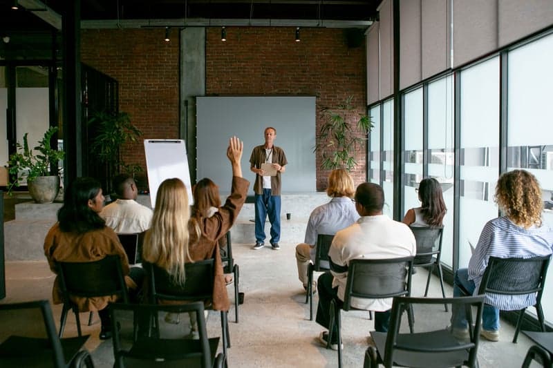 Facilitador guiando un programa de formación a un grupo de participantes