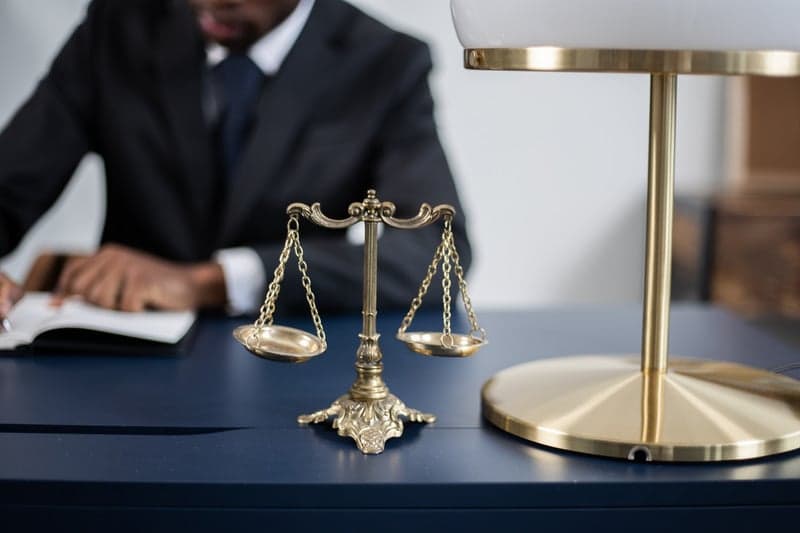 Balanza de la justicia junto a un abogado corporativo