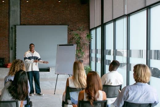 Facilitador guiando una sesión de formación con participantes de empresas