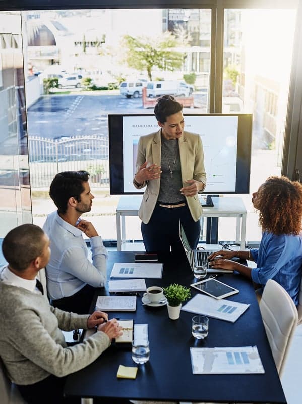 Facilitadora exponiendo frente a un equipo durante una sesión de trabajo